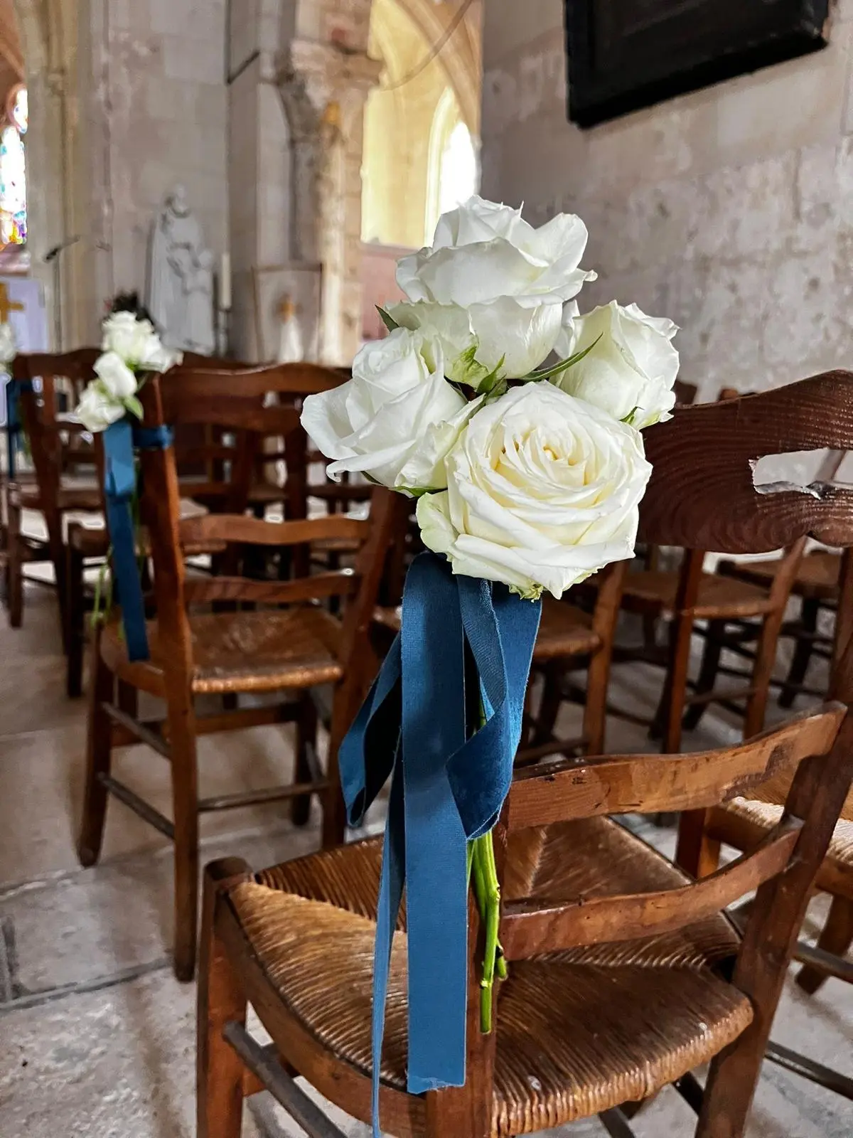 Décoration chaise église mariage roses blanches