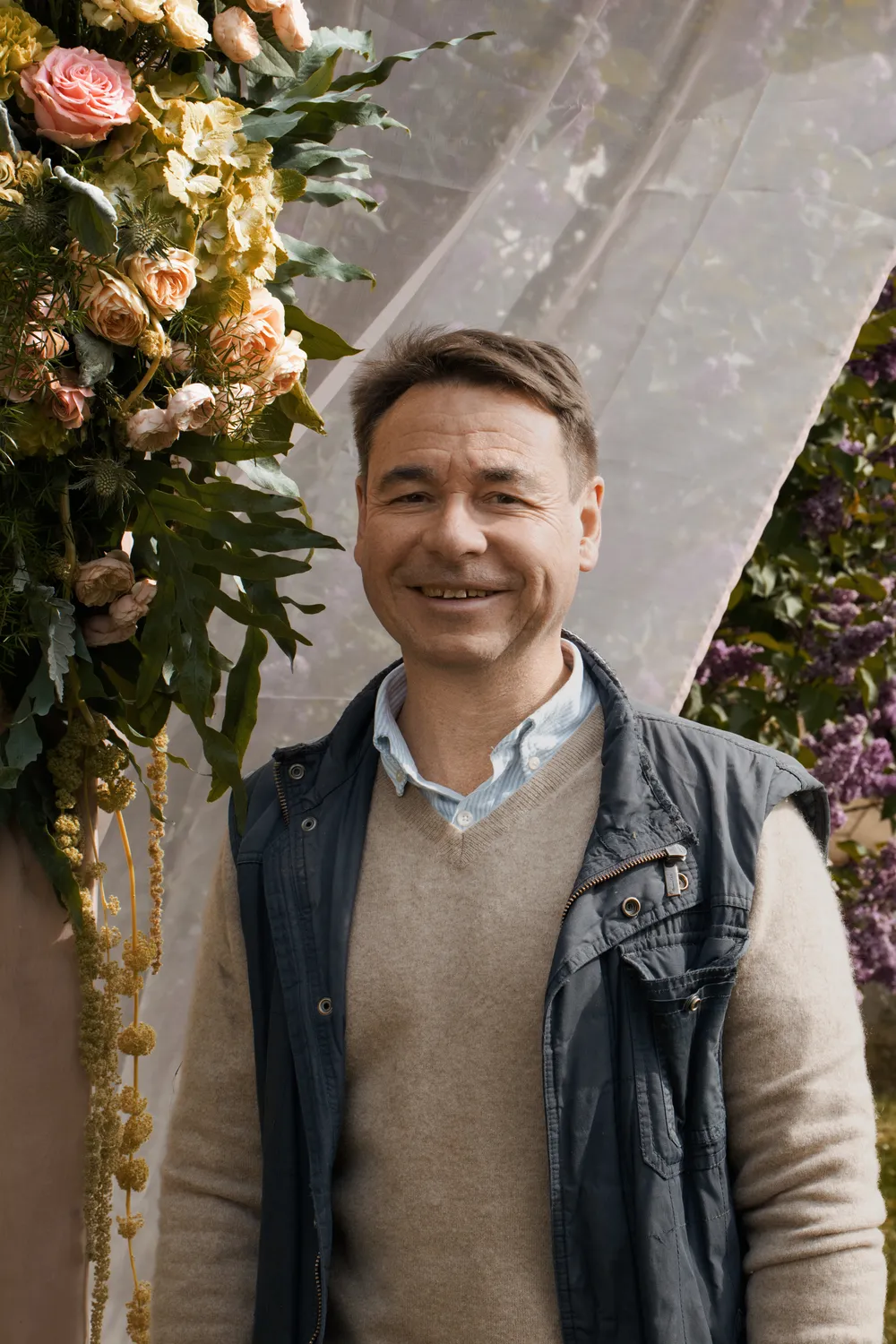 Olivier Brouillard, artisan fleuriste à Soissons, devant une arche florale de mariage qu'il a réalisée